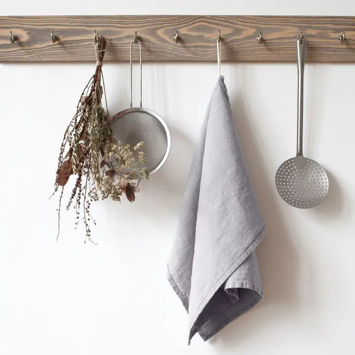 Light Grey Linen Kitchen Towel vaaleanharmaa pellava keittiöliina roikkuu seinällä.