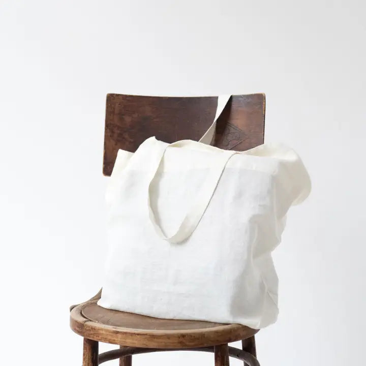White Linen Big Bag valkoinen iso pellavakankainen kangaskassi on tuolilla.