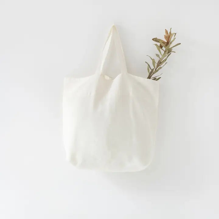 White Linen Big Bag valkoinen pellavainen kangaskassi roikkuu seinällä.